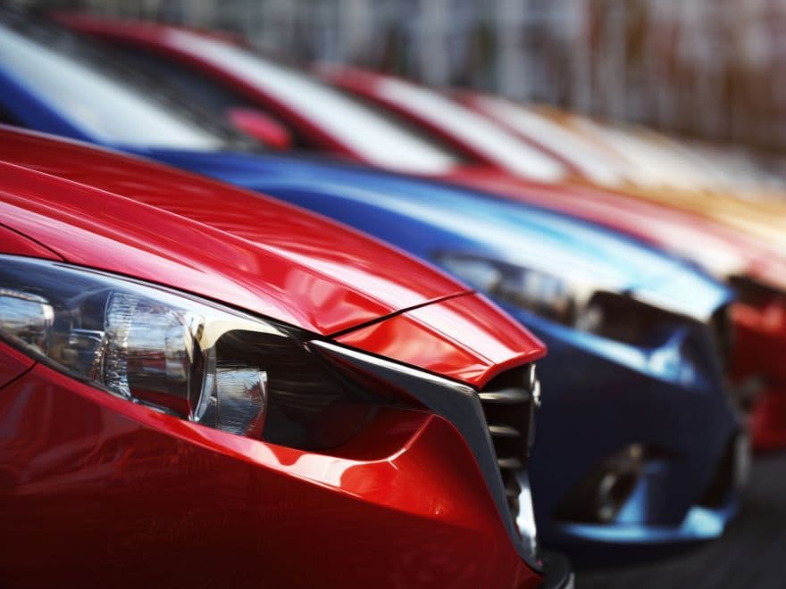 Fileira de carros novos e seminovos em estoque de concessionária, destacando como a automação de vendas no WhatsApp ajuda na rotatividade do inventário.